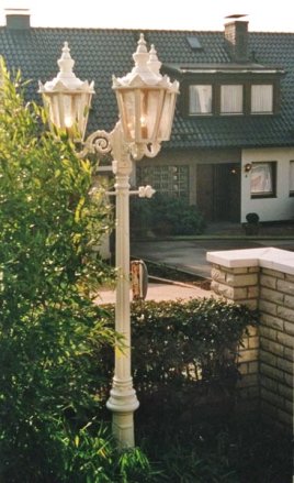 3-flammige Gartenleuchte 'Rheinland-Maxi'. Hier abgebildet in weiß, mit Altdeutschem Glas und Fassungshülsen aus Messing.Höhe: 2,55mMast und Krone aus rostfreiem Gußaluminium.Leiterbügel kann auf Wunsch entfallen.